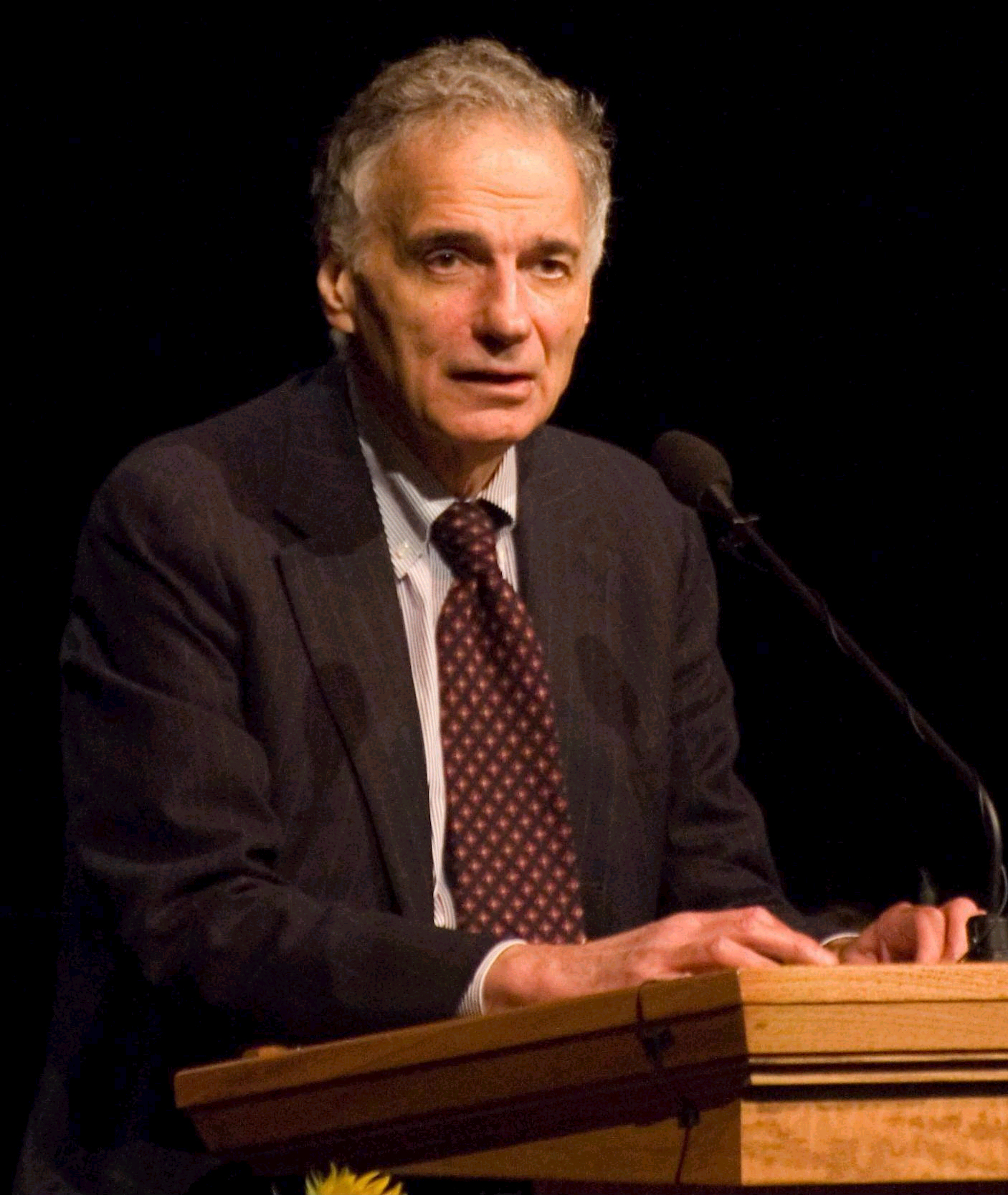 Ralph Nader parla da un leggio con il microfono, in un'immagine dagli anni della sua candidatura presidenziale